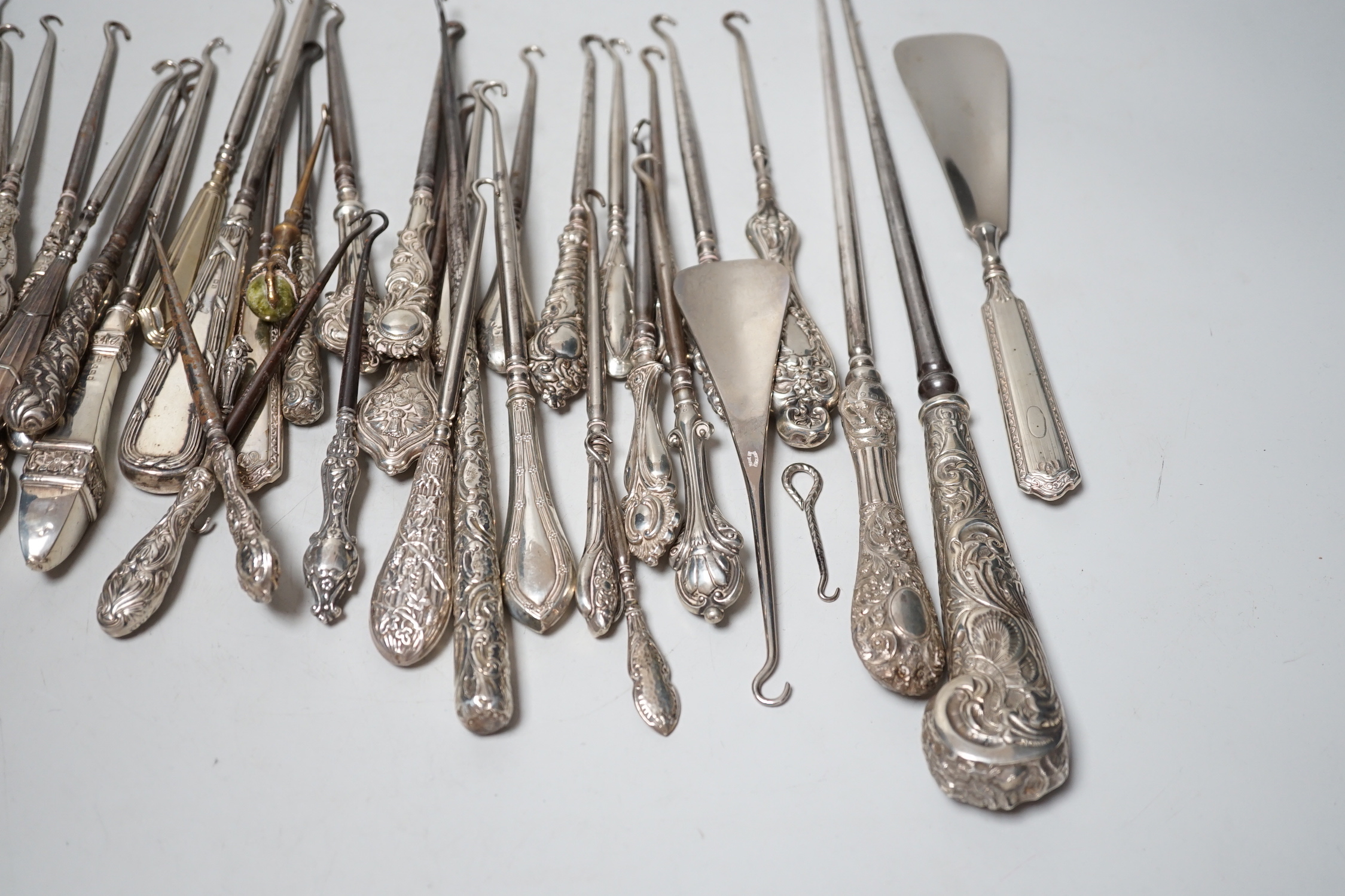 A large collection of mainly silver handled button hooks and two shoe horns.